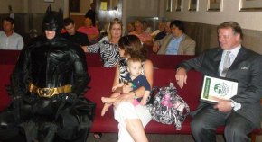 Caped Crusader Asks for Partnership with Council Batman takes his seat before the meeting